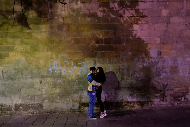 A couple kiss on a street in Barrio Gotico (Gothic Quarter), in Barcelona, Spain on January 13, 2021. (Photo by Nacho Doce/Reuters)
