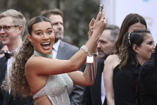 Actress Montana Brown takes a photograph upon arrival at the 75th British Academy Film Awards, BAFTA's, in London Sunday, March 13, 2022. (Photo by Vianney Le Caer/Invision/AP Photo)