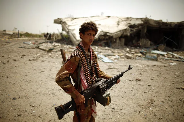 An army soldier stands near a building destroyed during recent fighting between the army and al Qaeda-linked militants in the southern Yemeni city of Zinjibar June 21, 2012. (Photo by Khaled Abdullah/Reuters)