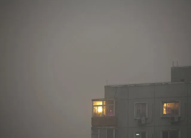 Apartment rooms are lit up with lights during daytime on an extremely polluted day as hazardous, choking smog continues to blanket Beijing, China December 1, 2015. (Photo by Kim Kyung-Hoon/Reuters)