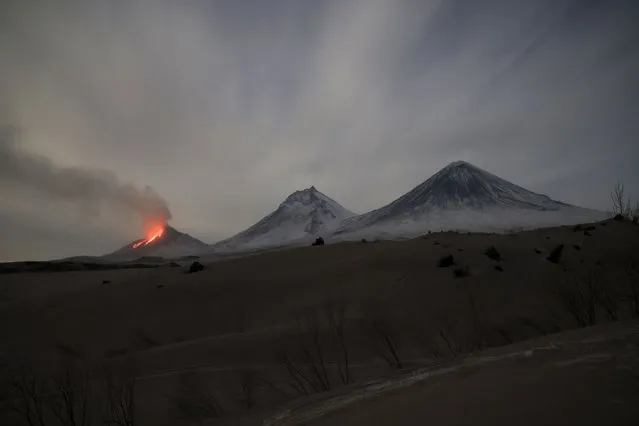 Lava and steams are visible during the the Bezymianny volcano's eruption, left, with the Kamen volcano, center, and Klyuchevskaya sopka volcano, right, on the Kamchatka Peninsula in Russia, Saturday, April 8, 2023. On Friday, the Bezymyanny volcano emitted ash up to 10,000 meters (32,808 feet) high. The volcano was assigned danger code red for aviation. The Kamchatka Peninsula, which extends into the Pacific Ocean about 6600 kilometers (4,000 miles) east of Moscow, is one of the world's most concentrated area of geothermal activity, with about 30 active volcanoes. (Photo by Yury Demyanchuk, The Russian Academy of Sciences' Vulcanology Institute via AP Photo)