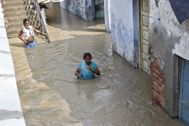 Residents wade through an alley flooded with the rising water level of river Yamuna after heavy monsoon rains in New Delhi June 19, 2013. The rains are at least twice as heavy as usual in northwest and central India as the June-September monsoon spreads north, covering the whole country a month faster than normal. (Photo by Anindito Mukherjee/Reuters)
