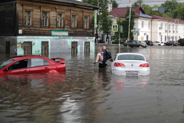 A woman is rescued from a car after a flash flood in Nizhny Novgorod, Russia on June 19, 2018. (Photo by Lucy Nicholson/Reuters)