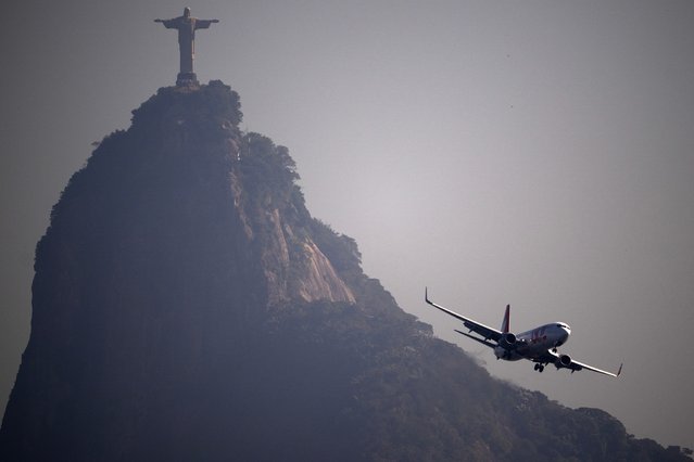 An aircraft from the Gol airline company prepares to land at Santos Dumont airport with the Christ the Redeemer statue in the background in Rio de Janeiro, Brazil, on June 16, 2025. (Photo by AFP Photo/Stringer)
