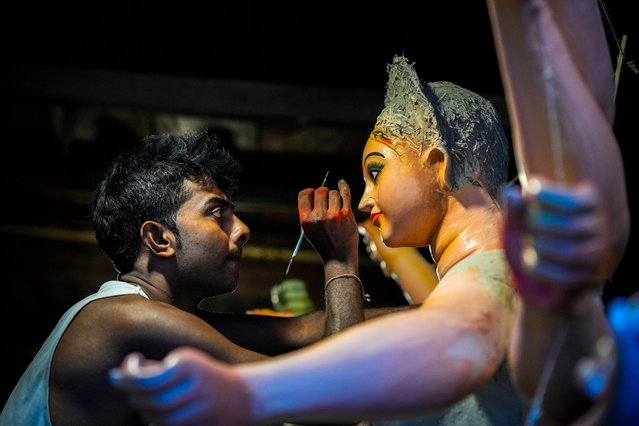 Kanchan Paul, 39, paints the eyes on an idol of the Hindu goddess Durga at his workshop during the Durga Puja festival in Guwahati, India, Friday, October 4, 2024. (Photo by Anupam Nath/AP Photo)