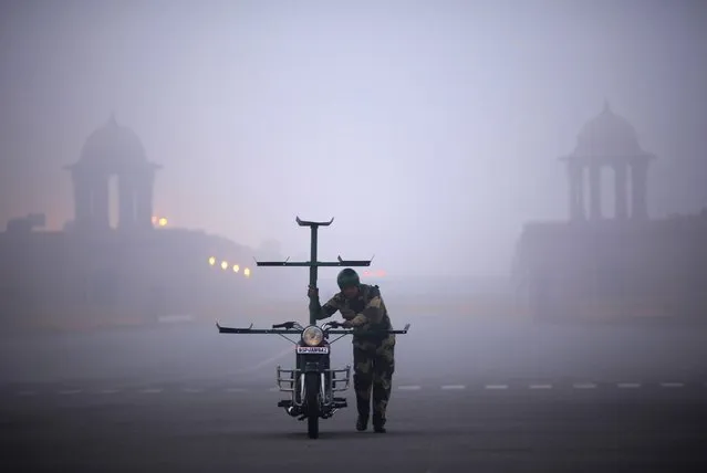 An India's Border Security Force (BSF) “Daredevils” motorcycle rider arrives to perform during the rehearsal for the Republic Day parade on a foggy winter morning in New Delhi January 16, 2015. (Photo by Ahmad Masood/Reuters)