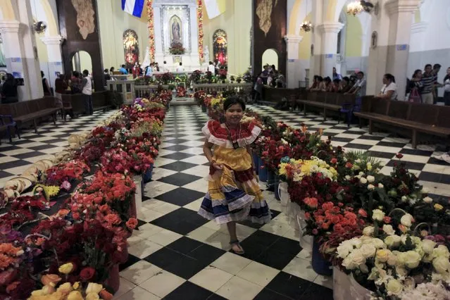 A girl runs down an aisle amidst offerings left by devotees to celebrate the Day of the Virgin of Guadalupe inside the Basilica of Guadalupe in San Salvador, El Salvador December 11, 2015. (Photo by Jose Cabezas/Reuters)