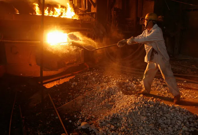 A labourer shovels iron ore into a steel ladle at Wuhan Iron and Steel Group in the capital of central China's Hubei province October 17, 2007. (Photo by Reuters/Stringer)