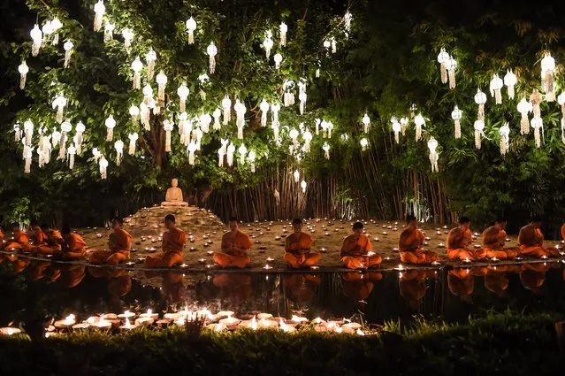 Novice Buddhist monks sit to pray at Wat Phan Tao temple to mark the beginning of the annual Yi Peng festival in the popular tourist city of Chiang Mai in the north of Thailand on November 13, 2016. Restrictions on festivals and celebrations around the country are beginning to ease one month after the death of Thailand's King Bhumibol Adulyadej at the age of 88 on October 13, as authorities try to balance national mourning with the need to capitalise on the current peak tourist season. (Photo by Lillian Suwanrumpha/AFP Photo)