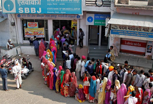 People queue outside a bank to exchange and deposit their old high denomination banknotes in Masuda village in the desert Indian state of Rajasthan, India, November 15, 2016. (Photo by Himanshu Sharma/Reuters)