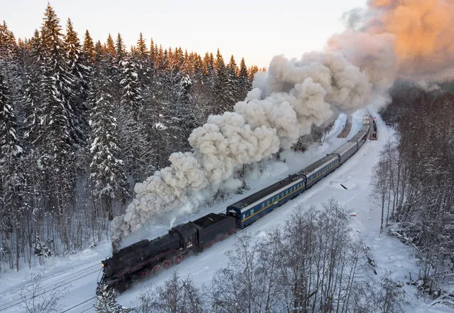 A Soviet-era steam locomotive pulls a retro train taking tourists to the Ruskeala natural park from the city of Sortavala, Karelia region, Russia on February 18, 2021. Russia’s rollout of its coronavirus vaccine is only now picking up speed in some of its more remote regions. The experts blame the slow rollout on limited supplies of the vaccine, logistical difficulties in distribution and continued hesitance among some Russians. (Photo by Dmitri Lovetsky/AP Photo/File)