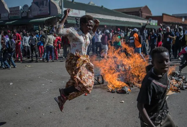 Opposition MDC party supporters protest in the streets of Harare during clashes with police Wednesday, August 1, 2018. Hundreds of angry opposition supporters outside Zimbabwe's electoral commission were met by riot police firing tear gas as the country awaited the results of Monday's presidential election, the first after the fall of longtime leader Robert Mugabe. (Photo by Mujahid Safodien/AP Photo)