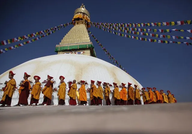 Buddhist monks circle around the Boudhanath Stupa during the last day of its purification ceremony in Kathmandu, Nepal, Sunday, November 20, 2016. A three-day purification ceremony was organized to purify the Boudhanath Stupa, which was damaged in the 2015 earthquake, after the completion of its reconstruction. The Stupa will officially open to the public on Nov 22. (Photo by Niranjan Shrestha/AP Photo)