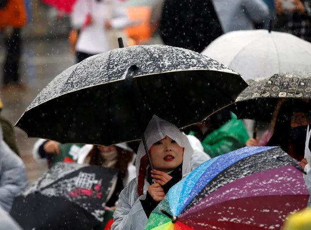 A protester holds an umbrella at a protest calling for South Korean President Park Geun-hye to step down, as it snows in Seoul, South Korea, November 26, 2016. (Photo by Kim Kyung-Hoon/Reuters)