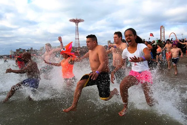 People enter the water during the Coney Island Polar Bear Club's annual New Year's Day swim at Coney Island in the Brooklyn borough of New York, January 1, 2016. (Photo by Andrew Kelly/Reuters)