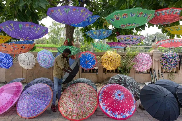 A roadside vendor sells umbrellas along a road in Amritsar on July 11, 2023. (Photo by Narinder Nanu/AFP Photo)