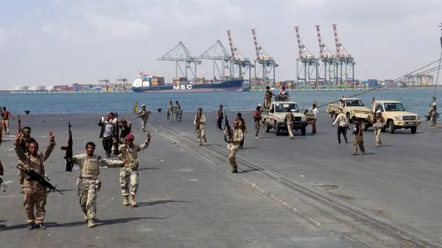 Army soldiers celebrate after taking over the main port of Yemen's southern city of Aden from gun men, January 4, 2016. Yemeni authorities announced a dusk to dawn curfew in Aden starting on Monday following a night of gunbattles between armed men and government forces that killed at least 12 people from both sides, a local government spokesman said. The government of President Abd-Rabbu Mansour Hadi has been grappling with lawlessness in the southern port since militiamen, backed by a Saudi-led Arab alliance, drove the Iran-allied Houthis out in July. (Photo by Reuters/Stringer)