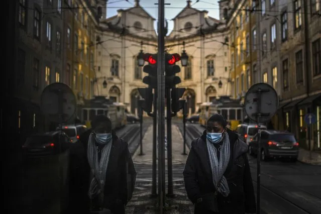 A woman wearing a face mask is reflected in a shop window while walking in Lisbon on January 15, 2021 as Portugal entered a fresh lockdown over a surge in coronavirus cases. The novel coronavirus has killed at least 1,994,833 people since the outbreak emerged in China in December 2019, according to a tally from official sources compiled by AFP. (Photo by Patricia De Melo Moreira/AFP Photo)