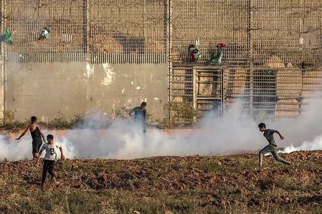 Palestinian protesters run through tear gas fumes fired by Israeli forces during a demonstration along the border between the Gaza Strip and Israel, east of Gaza City on September 1, 2023. (Photo by Mohammed Abed/AFP Photo)