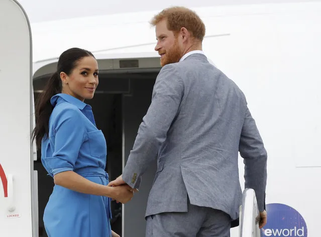 Britain's Prince Harry and Meghan, Duchess of Sussex wave before departing from Fua'amotu International Airport, Tonga, Friday, October 26, 2018. Prince Harry and his wife Meghan are on day 11 of their 16-day tour of Australia and the South Pacific. (Photo by Phil Nobel/Pool Photo via AP Photo)
