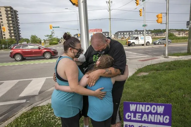 People show up to the location where a family of five was hit by a driver, in London, Ontario, Monday, June 7, 2021. Multiple members of the family died and one is in critical condition. A 20 year old male has been charged with four counts of first degree murder and count of attempted murder in connection with the crime. (Photo by Brett Gundlock/The Canadian Press via AP Photo)