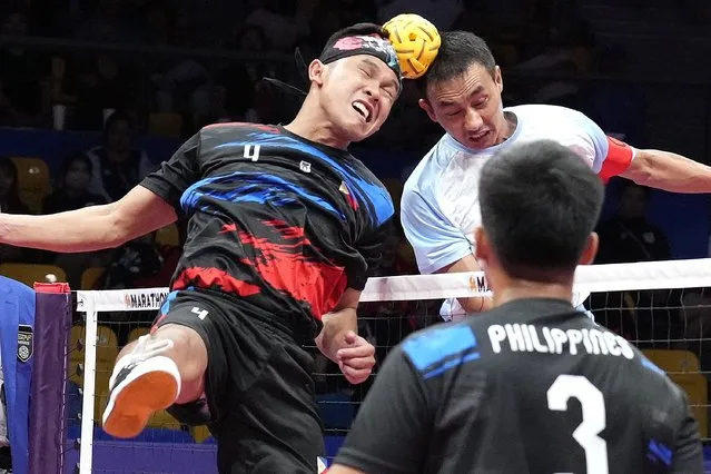 Philippines' Rheyjey Ortouste, left, and India's Niken Singh Khangembam, right, head the ball during men's sepaktakraw Group B preliminary match at Jinhua Sports Centre at the 19th Asian Games in Jinhua, China, Jinhua, Monday, October 2, 2023. (Photo by Eugene Hoshiko/AP Photo)