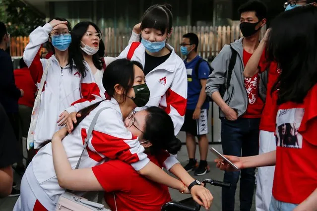 A student hugs her friend before entering the exam venue to take part in the annual national college entrance exam, or “gaokao”,  in Beijing, China on June 7, 2021. (Photo by Tingshu Wang/Reuters)