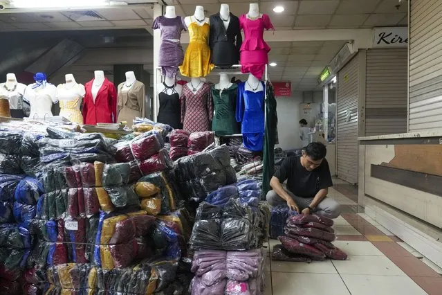 A seller wraps merchandise to send to his customers who he's dealing, using live streaming at a store in the Tanah Abang textile market in Jakarta, Indonesia, Wednesday, October 4, 2023. TikTok said it will halt its online-retail operation in Indonesia on Wednesday to comply with the country's decision to ban e-commerce transactions on social media platforms a big blow to the video platform's. (Photo by Tatan Syuflana/AP Photo)