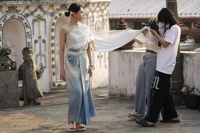A Chinese tourist rents traditional Thai costumes and poses for a photographer at Wat Arun, or the “Temple of Dawn”, in Bangkok, Thailand, on January 12, 2023. Thailand's new cabinet has approved a temporary visa exemption for tourists from China and Kazakhstan in its first meeting on Wednesday, Sept. 13, for a bid to boost tourism and the economy. (Photo by Sakchai Lalit/AP Photo)