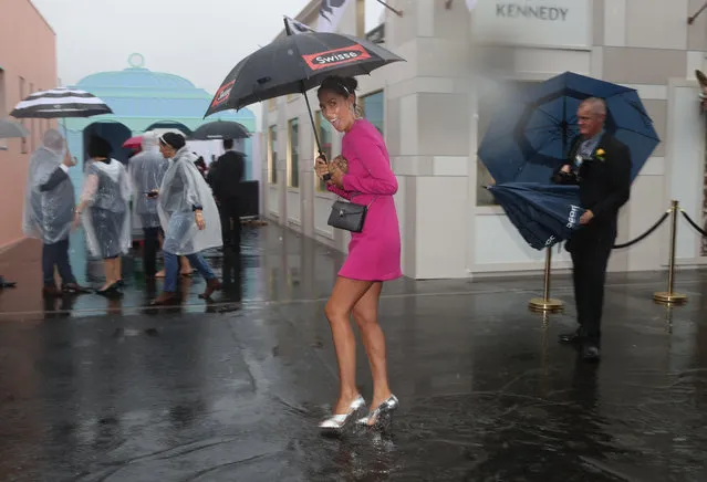 A general view is seen as racegoers walk in puddles as rain tumbles down after race 1 the Ottawa Stakes during Melbourne Cup Day at Flemington Racecourse on November 6, 2018 in Melbourne, Australia. (Photo by Dave Crosling/AAP)