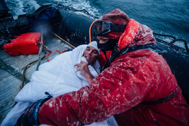 In this February 19, 2015 photo, provided by 5 Swims Expedition, Lewis Pugh, of the United Kingdom, is wrapped in blankets to help warm his body in the Ross Sea in Antarctica. (Photo by Kelvin Trautman/AP Photo)