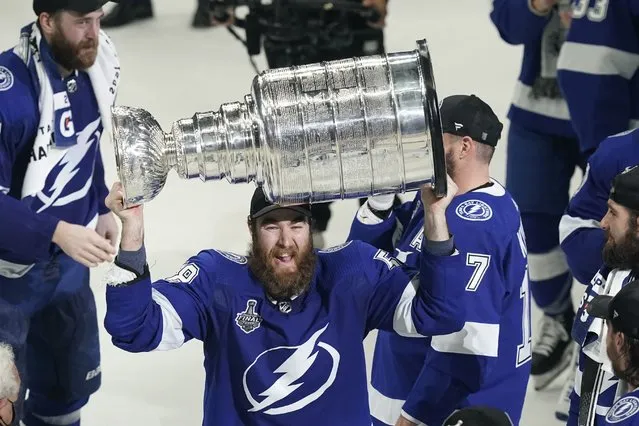 Tampa Bay Lightning defenseman David Savard hoists the Stanley Cup after the series win in Game 5 of the NHL hockey Stanley Cup finals against the Montreal Canadiens, Wednesday, July 7, 2021, in Tampa, Fla. (Photo by Gerry Broome/AP Photo)