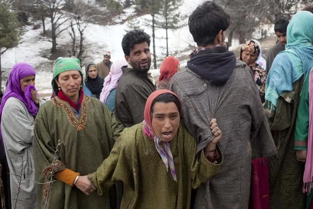 An unidentified woman comforts a relative, center, of landslide victims in the village of Laden some 45 Kilometers (28 miles) west of Srinagar, Indian-controlled Kashmir, Monday, March 30, 2015. (Photo by Dar Yasin/AP Photo)