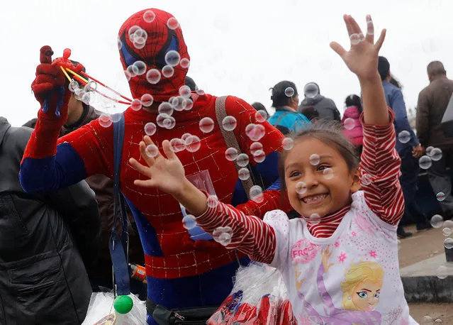 A girl plays with bubbles during celebrations for the feast of Saints Peter and Paul in Lima June 29, 2016. (Photo by Guadalupe Pardo/Reuters)