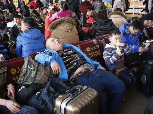 A passenger takes a nap at a waiting room as he waits for his train at Beijing Railway Station during the travel rush ahead of the upcoming Spring Festival in Beijing, China, February 4, 2016. (Photo by Kim Kyung-Hoon/Reuters)