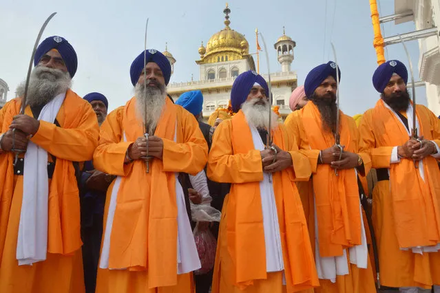 Indian Sikh holy men, known as “Panj Pyare”, hold Sikh swords during a procession from Sri Akal Takht Sahib at the Golden Temple in Amritsar on January 4, 2017, on the eve of  the 350th birth anniversary of the tenth Sikh Guru Gobind Singh. (Photo by Narinder Nanu/AFP Photo)