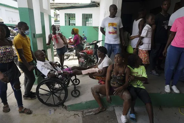 People injured in a car accident, sitting right, wait with others injured during the earthquake for x-rays at the General Hospital in Les Cayes, Haiti, Wednesday, August 18, 2021. (Photo by Fernando Llano/AP Photo)