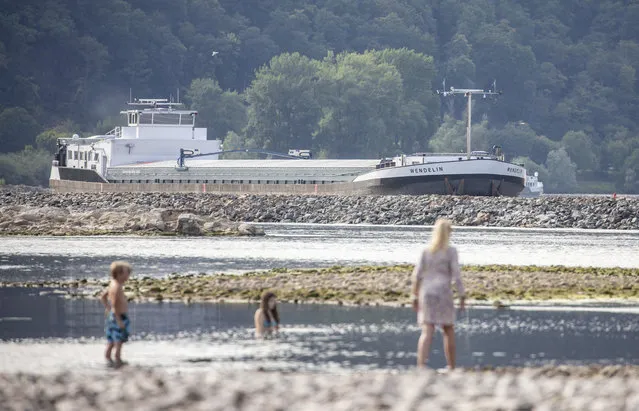People play at the Rhine river that has lost a lot of water due to the heat in Bingen, Germany, Sunday, July 29, 2018. (Photo by Frank Rumpenhorst/DPA via AP Photo)