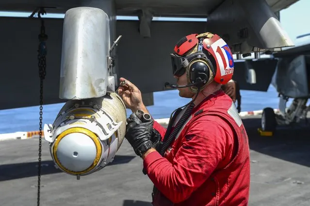 A Sailor prepares ordinance for an F/A-18F Super Hornet on the flight deck of the aircraft carrier USS Theodore Roosevelt in this U.S. Navy photo taken April 21, 2015. (Photo by Mass Communication Specialist 3rd Class Josh Petrosino/Reuters/U.S. Navy)