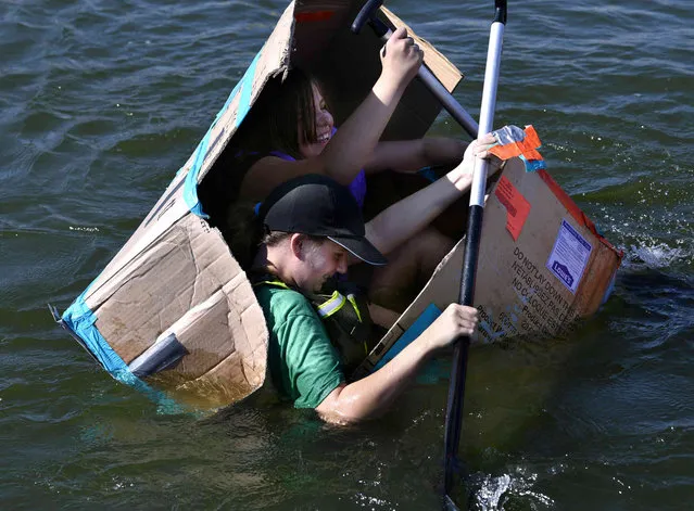 Izabella McCutchen, in green, and Hannah Collins, both 12, keep paddling as their S.S. Sharqueisha takes on water and slowly folds inward halfway through the course Saturday, September 18, 2021, in Abilene, Texas. Local Scouts held their first Cardboard Boat Regatta on Lake Fort Phantom Hill at the Abilene Sailing Association. (Photo by Ronald W. Erdrich/The Abilene Reporter-News via AP Photo)