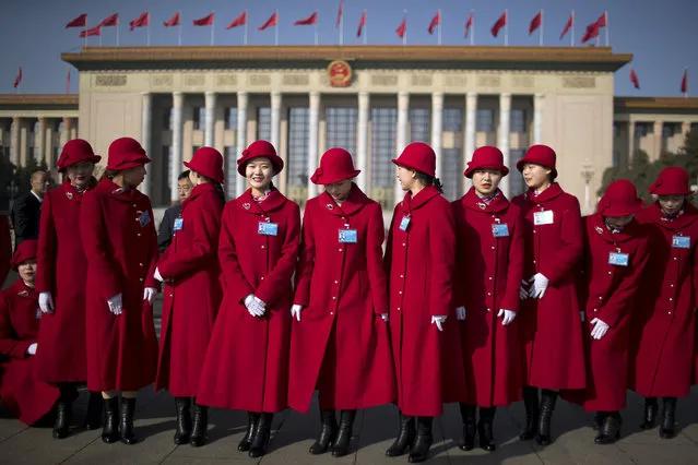 Bus ushers line up for a group photo during the opening session of China's National People's Congress (NPC) at the Great Hall of the People in Beijing, Tuesday, March 5, 2019. China's government announced a robust annual economic growth target and a 7.5 percent rise in military spending Tuesday at a legislative session overshadowed by a tariff war with Washington. (Photo by Mark Schiefelbein/AP Photo)