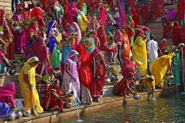 Hindu women collect water from the Pushkar lake to pour on idols of Lord Shiva, on occasion of Mahashivratri festival in Pushkar, India, Monday, March 7, 2016. Hindus across the world are celebrating Mahashivratri, or Shiva's night festival believed to be the day when Shiva got married. (Photo by Rajesh Kumar Singh/AP Photo)
