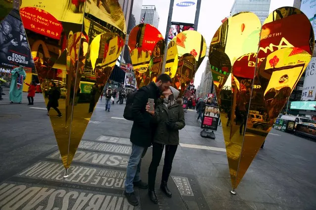 (L-R) Caio Nader kisses his girlfriend Juliana Avilla, both from Rio de Janeiro, Brazil, at the “Heart of Hearts” installation by Collective-LOK, which won the annual Times Square Valentine Heart Design competition, in Times Square, New York February 10, 2016. (Photo by Andrew Kelly/Reuters)