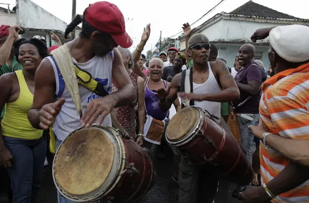 In this February 5, 2014 photo, people play drums during the Burial of Pachencho celebration in Santiago de Las Vegas, Cuba. (Photo by Franklin Reyes/AP Photo)