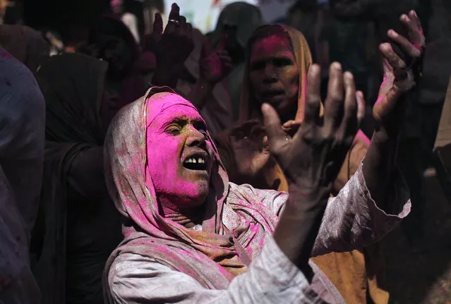 A widow daubed in colours sings religious songs as she takes part in the Holi celebrations organised by non-governmental organisation Sulabh International at a temple at Vrindavan, in the northern state of Uttar Pradesh, India, March 21, 2016. (Photo by Anindito Mukherjee/Reuters)