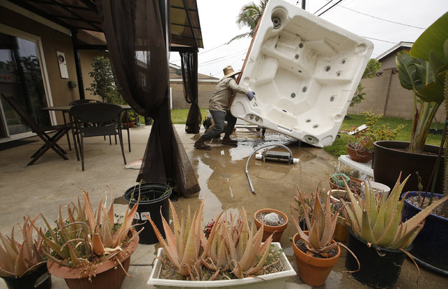 Spa Removers worker Juan Alexander empties a spa with a 400 gallon capacity for permanent removal at a residence in which the owner considered it “a waste of water”, in  Garden Grove, Calif., Wednesday, May 6, 2015.More than a century ago, a community in the heart of Orange County won its name from its founder's vision of planting trees and verdant landscapes where there was open plain. (Photo by Damian Dovarganes/AP Photo)