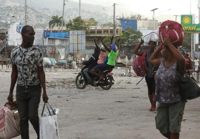 People flee their homes as police confront armed gangs after prominent gang leader Jimmy Cherizier called for Haiti's Prime Minister Ariel Henry's government to be toppled, in Port-au-Prince, Haiti, on February 29, 2024. (Photo by Ralph Tedy Erol/Reuters)