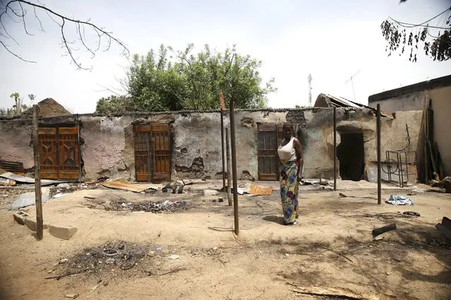 A woman stands in front of a burnt building in Michika town, after the Nigerian military recaptured it from Boko Haram, in Adamawa state May 10, 2015. (Photo by Akintunde Akinleye/Reuters)