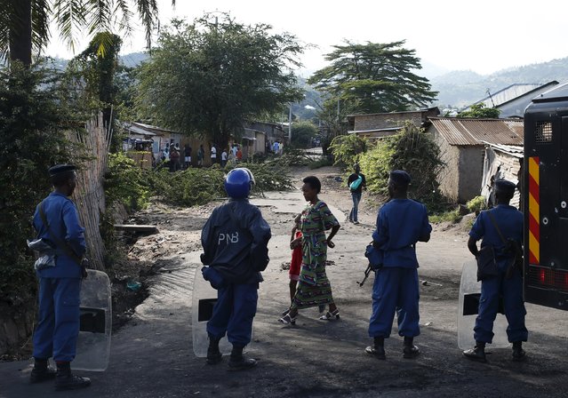 A woman and her daughter walk past policemen in Bujumbura, Burundi, May 10, 2015. (Photo by Goran Tomasevic/Reuters)