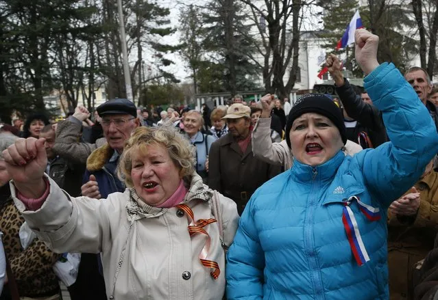 Pro-Russia demonstrators rally in front of the local parliament building in Crimea's capital Simferopol, Ukraine, Thursday, March 6, 2014. About 50 people rallied outside the local parliament Thursday morning waving Russian and Crimean flags. Lawmakers in Crimea called a March 16 referendum on whether to break away from Ukraine and join Russia instead, voting unanimously Thursday to declare their preference for doing so. (Photo by Sergei Grits/AP Photo)